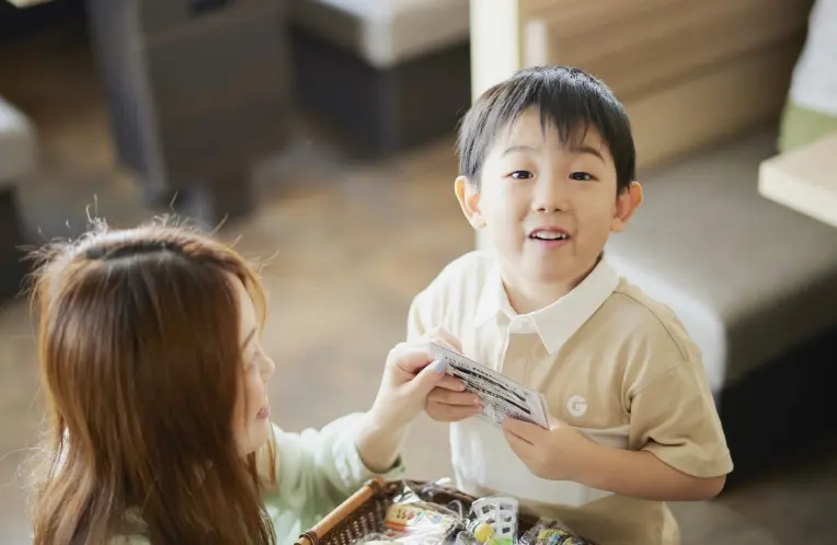 小さな男の子がおもちゃを受け取り、嬉しそうに笑っている